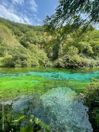 Transparent and turquoise waters in the blue eye or Syri i kalter in Albania under a clear blue sky in summer photo