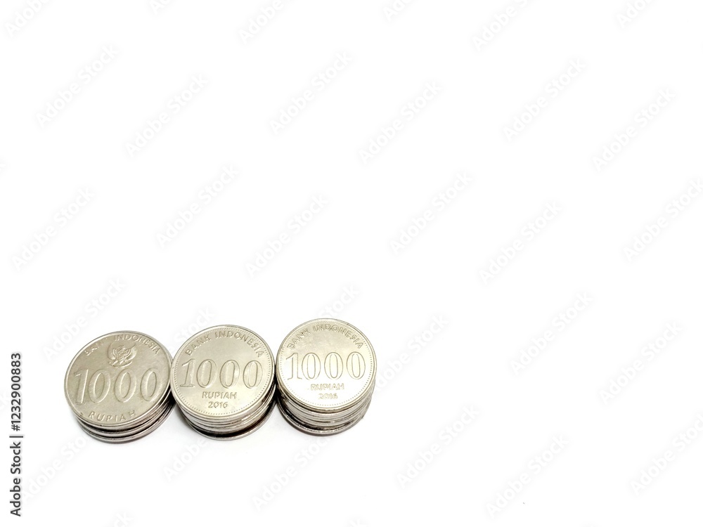 Indonesian coins stacked on a white background, elevated view
