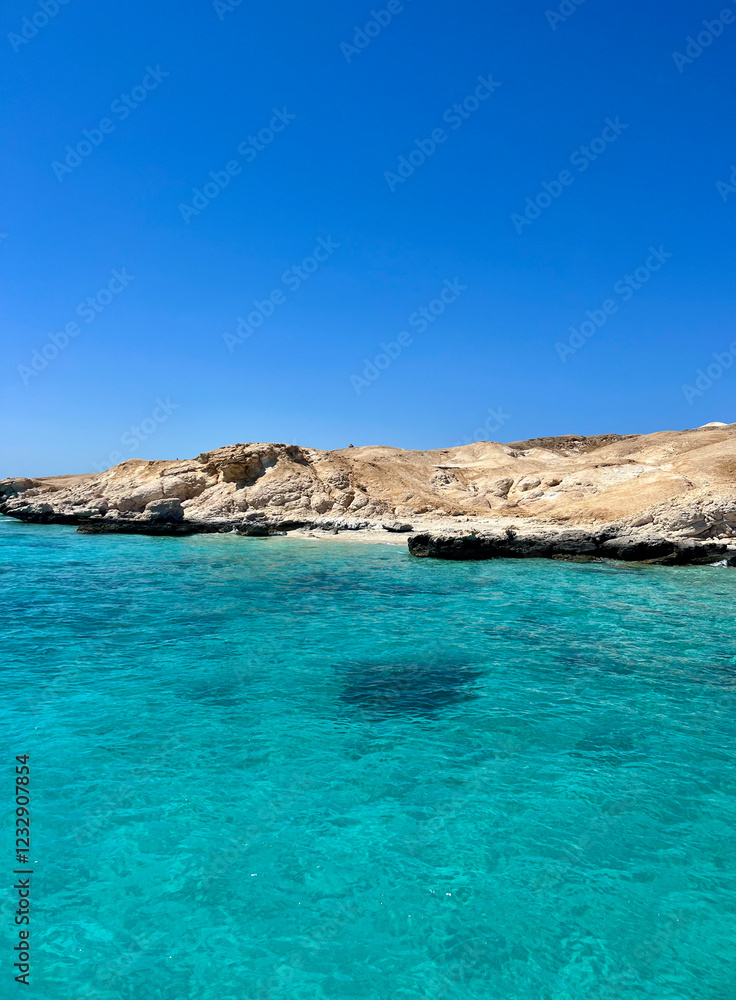 Bright blue skies surround the serene turquoise waters, gently lapping against rocky cliffs in Egypt. The clear sea reflects sunlight, creating a stunning coastal view. Bright blue skies surround the serene turquoise waters, gently lapping against rocky cliffs in Egypt. The clear sea reflects sunlight, creating a stunning coastal view.