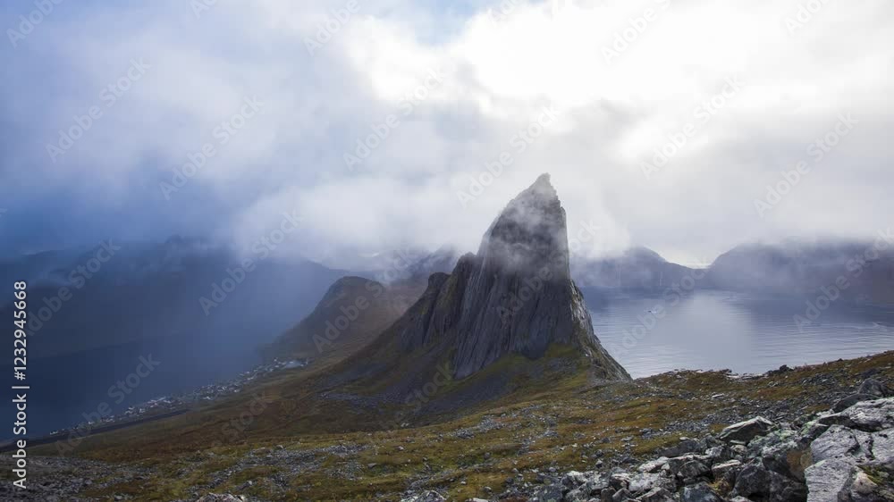 Segla mountain peak timelapse with moving clouds and sun rays in Senja, Norway Segla mountain peak timelapse with moving clouds and sun rays in Senja, Norway