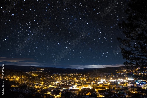 Night sky filled with stars over a city skyline with illuminated buildings an...