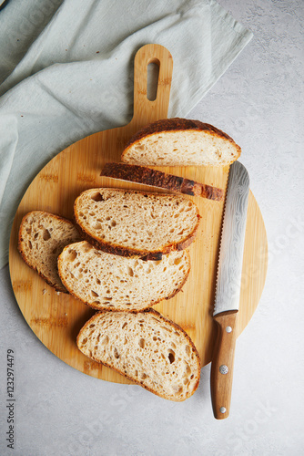 Fresh sourdough bread slices on a wooden cutting board photo