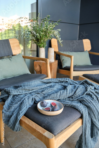 Modern balcony decor with natural elements and cozy textiles photo