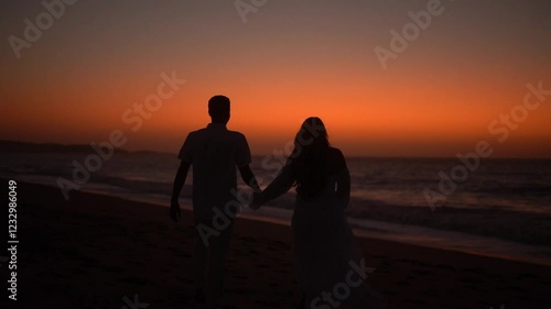 silhouette of couple walking on the beach