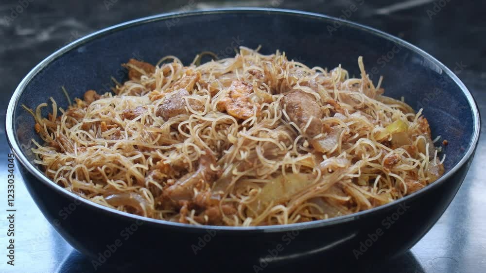 Stir fry rice vermicelli noodles with pork onion and dark soy sauce with steam in a bowl. Stir fry rice vermicelli noodles with pork onion and dark soy sauce with steam in a bowl.