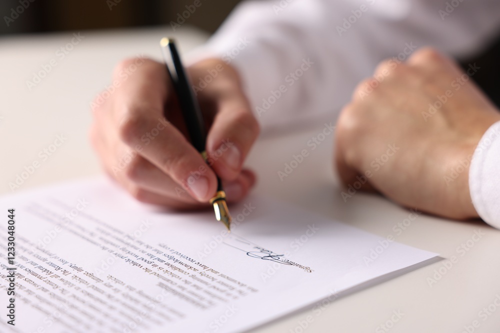 Man putting signature on document at white table, closeup Man putting signature on document at white table, closeup