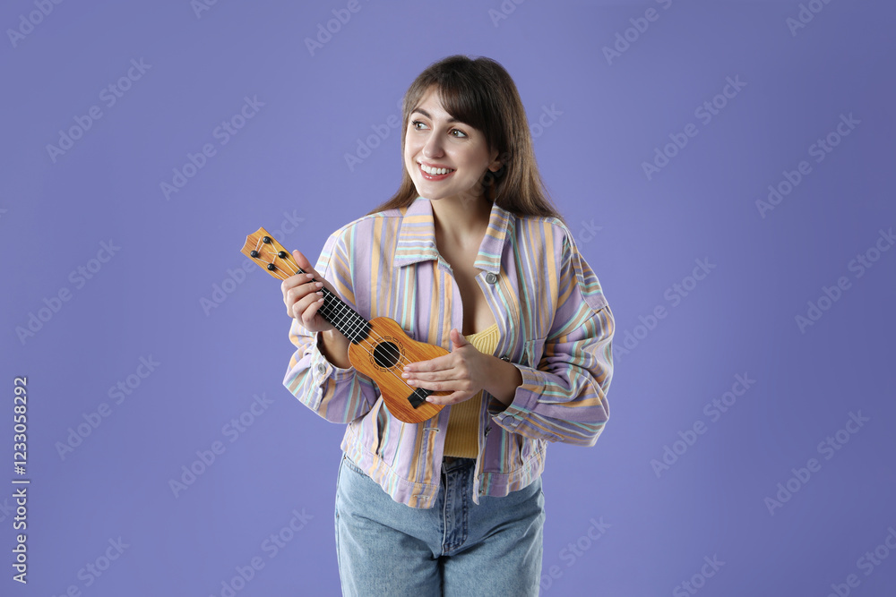 Happy woman playing ukulele on purple background Happy woman playing ukulele on purple background