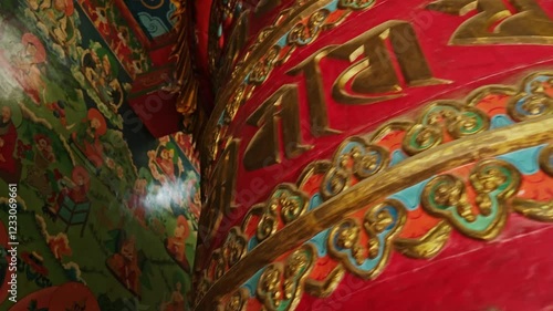 Wallpaper Mural Drugon Jangchu Monastery houses this vibrant prayer wheel adorned with sacred inscriptions. Spinning it is believed to spread blessings, purify karma,reflecting deep-rooted Buddhist traditions. Torontodigital.ca