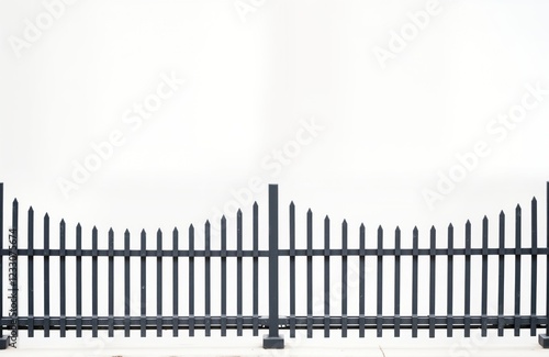 Grey metal fence with pointed posts. Simple design. Ideal for background elements in modern retro style photos. Suitable for garden park street scenes. Suggests security decorative elements. Clean photo