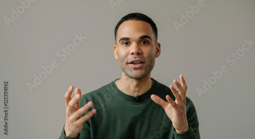 A man with a green shirt is talking to the camera