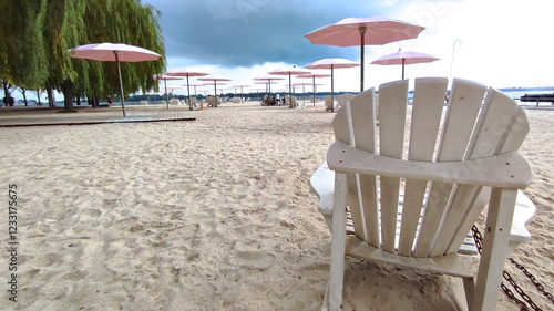 Canvas Print Adirondack chairs with pink umbrellas at the beach in the city