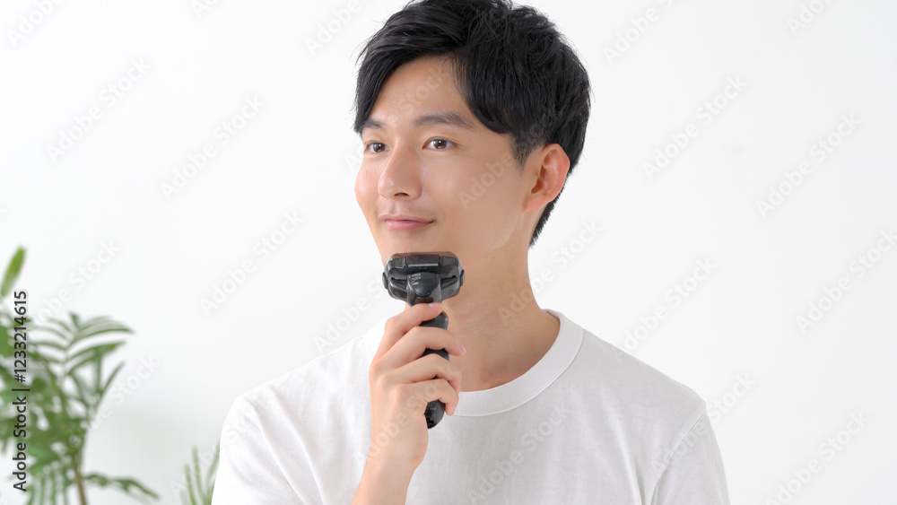シェーバーで髭を剃る男性