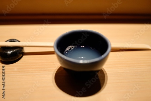 A small ceramic bowl of clear clam soup (ushio-jiru) with chopsticks at an omakase lunch at Manten Sushi Marunouchi near Tokyo Station and the Imperial Palace - Chiyoda City, Tokyo photo