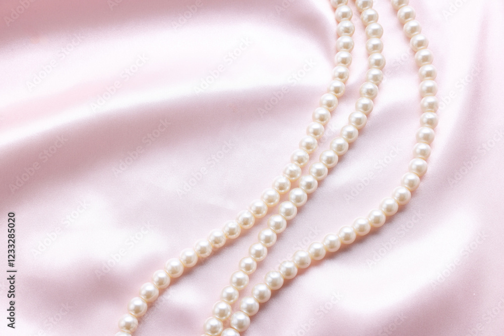 Elegant pearl necklace on pink fabric, top view. Space for text Elegant pearl necklace on pink fabric, top view. Space for text