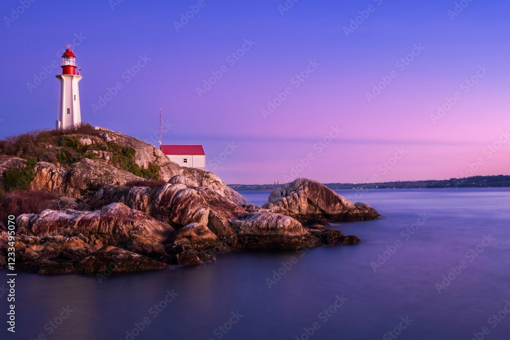 Obraz premium Lighthouse on rocky cliff at sunset against colorful sky. Lighthouse park. West Vancouver. British Columbia. Canada