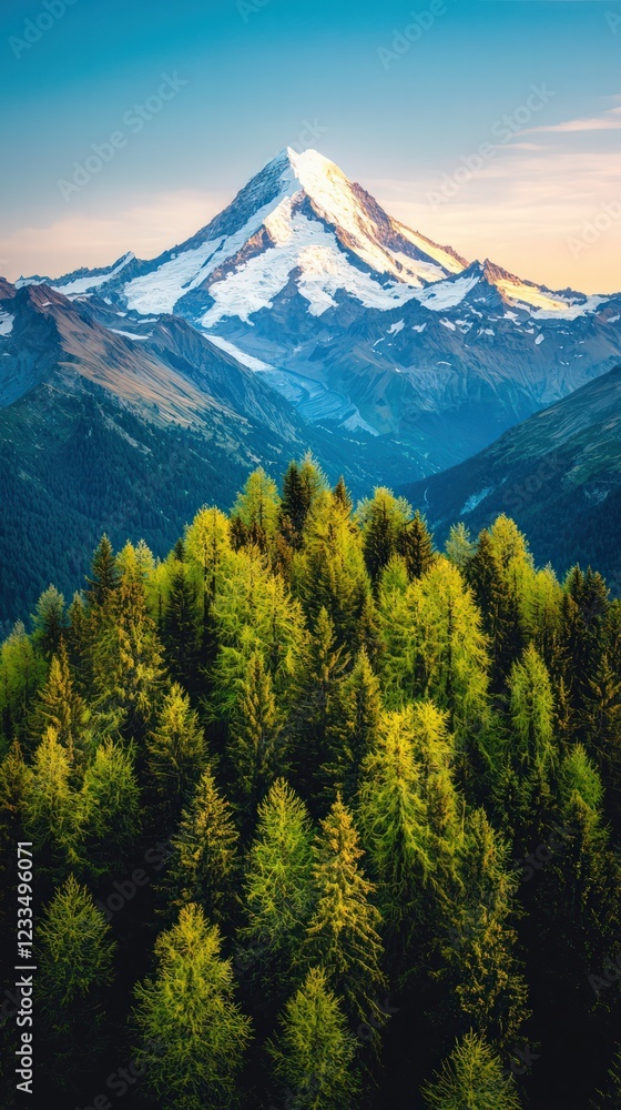 Majestic Snow-Capped Mountain Rising Above Lush Green Forest Under A Clear Blue Sky