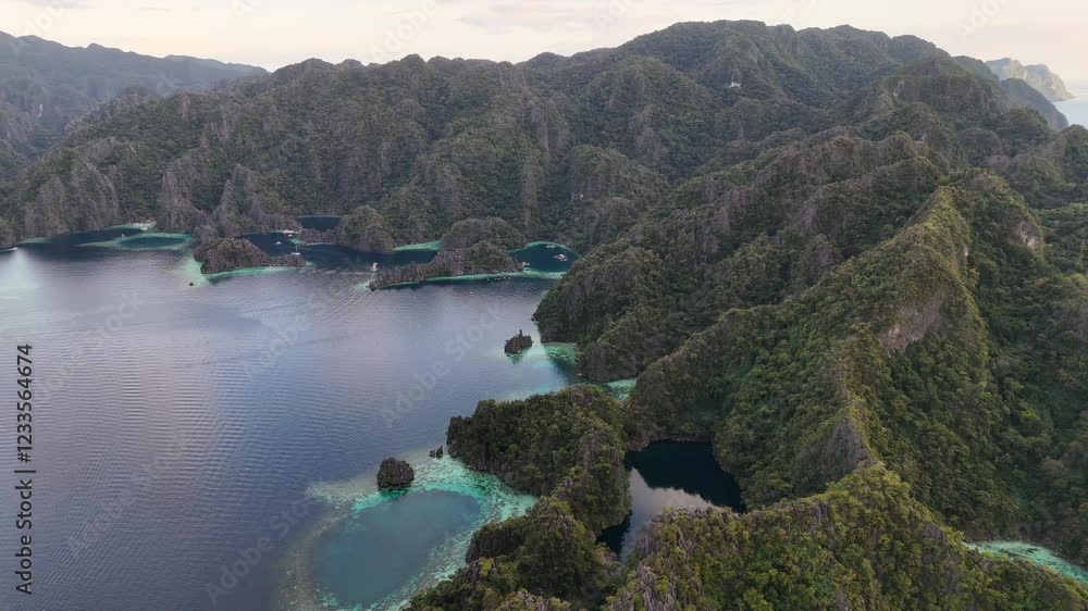 Aerial drone view of Coron Island’s dramatic cliffs, tropical greenery, and idyllic turquoise waters, Philippines. Wide rotating shot. Aerial drone view of Coron Island’s dramatic cliffs, tropical greenery, and idyllic turquoise waters, Philippines. Wide rotating shot.