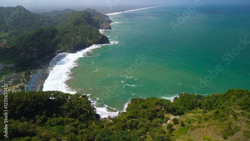 Bird eye view View of the coastline with hills and trees, cliffs, coral reefs and waves from the sea at Surumanis Beach, Kebumen, Central Java photo