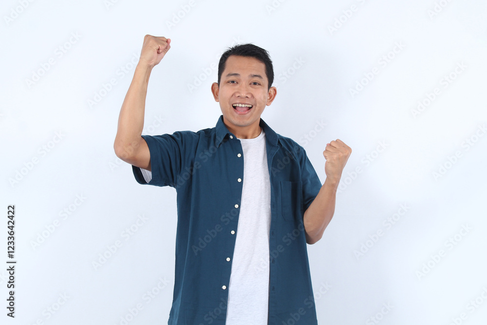 Adult Asian Man Celebrates Success with Enthusiasm, Raising Fists Triumphantly and Expressing Joy Adult Asian Man Celebrates Success with Enthusiasm, Raising Fists Triumphantly and Expressing Joy