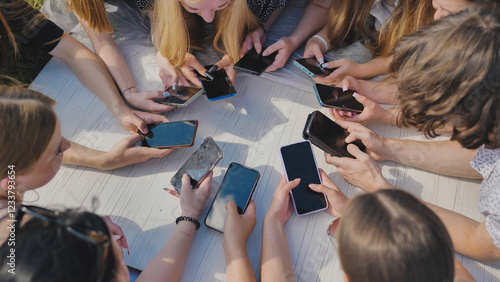 Young friends gather in a circle, using their smartphones to stay connected in the digital age