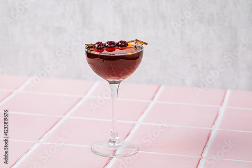 A manhattan cocktail in a coupe glass, garnished with cherries