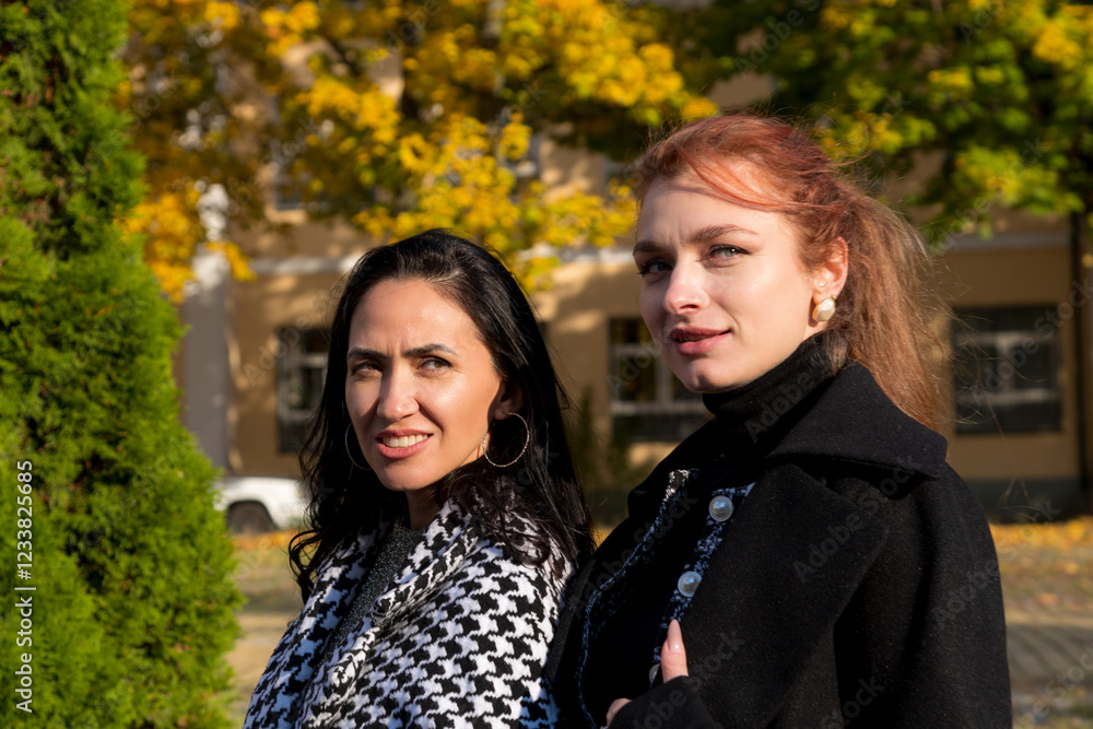 Stylish women enjoying a sunny autumn day while walking down the street Stylish women enjoying a sunny autumn day while walking down the street
