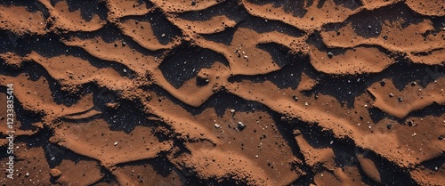 Smoky umber lava formed sand with speckled mineral deposits background