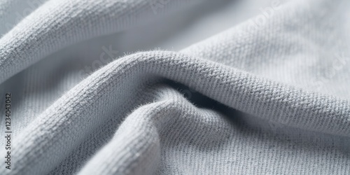 Close-up of textured gray fabric, featuring delicate wrinkles and softly curled edges, with gentle shadows adding depth and intrigue photo