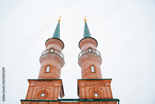 A sturdy brick building features two impressive towers that rise majestically atop its structure, enhancing its architectural beauty and serving as a notable landmark in the area photo