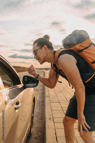 фотографія Man tourist backpacker asking for a ride to his destination.