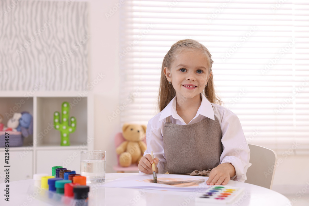 Smiling girl drawing at white table in kindergarten Smiling girl drawing at white table in kindergarten