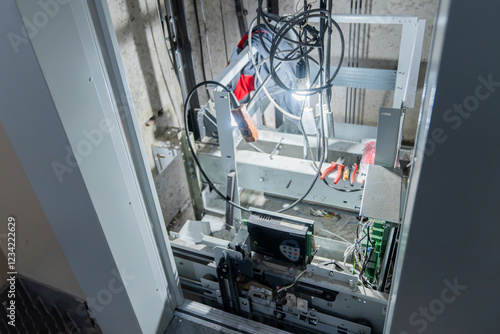 This is an interior view of an elevator shaft with essential mechanical parts and wiring photo