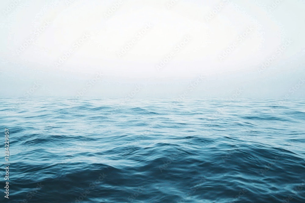 Fototapeta premium Serene view of gentle ocean waves extending to the horizon, blending into a soft and calm atmospheric background