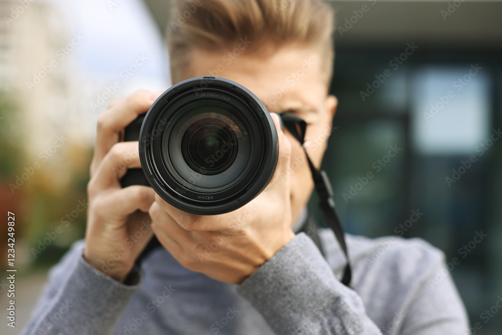 Professional photographer taking picture with camera outdoors, selective focus Professional photographer taking picture with camera outdoors, selective focus