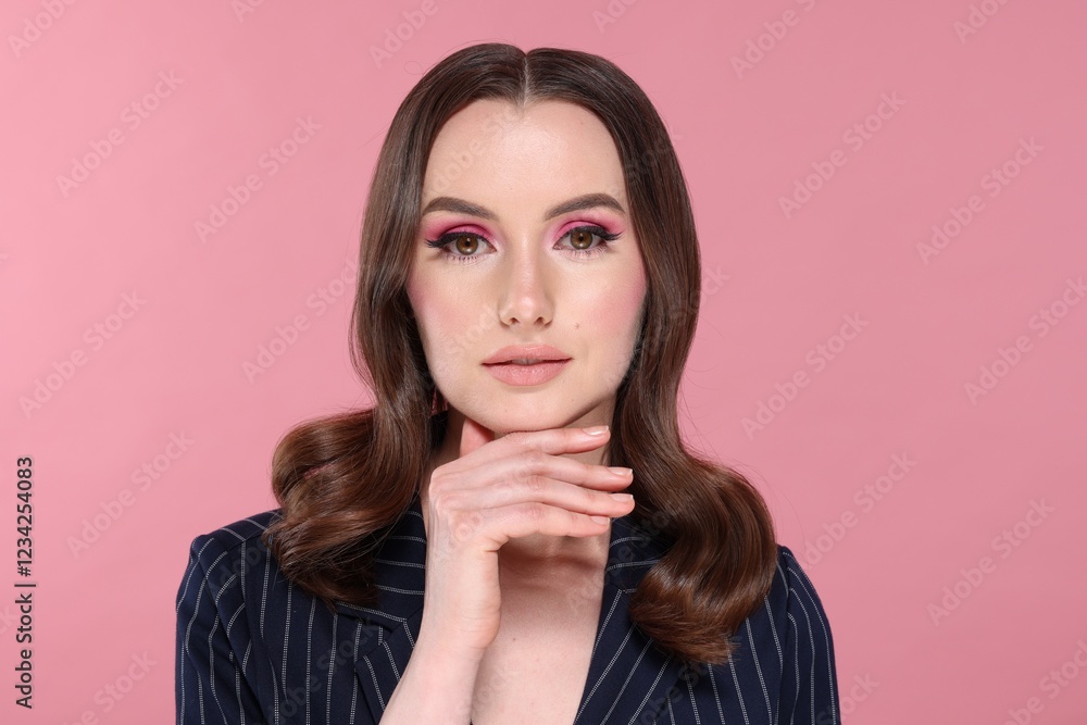 Portrait of beautiful young woman with stylish makeup and gorgeous hair on pink background Portrait of beautiful young woman with stylish makeup and gorgeous hair on pink background