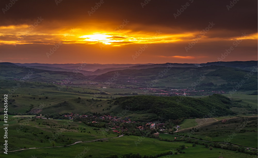 Aerial view of the lush green hills of Transylvania during sunset, showcasing the natural beauty and untouched landscapes of this Romanian region. Travel to Romania.