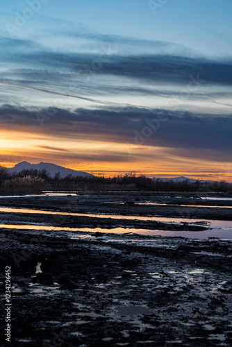 sunset in the area of the river mouth of the Bregenzer Ache into the Bodensee with reflections of the Swiss mountains and the sky photo