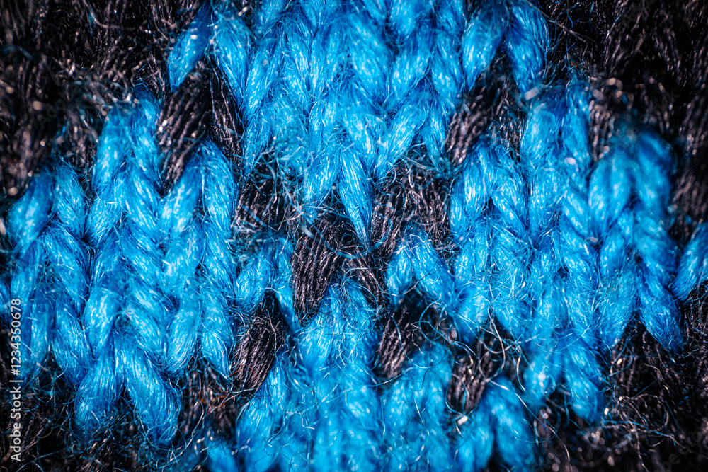 Obraz premium A detailed macro shot of blue and white knitted fabric, showcasing the soft texture and intricate weave of the yarn. The color contrast highlights the artistic pattern.