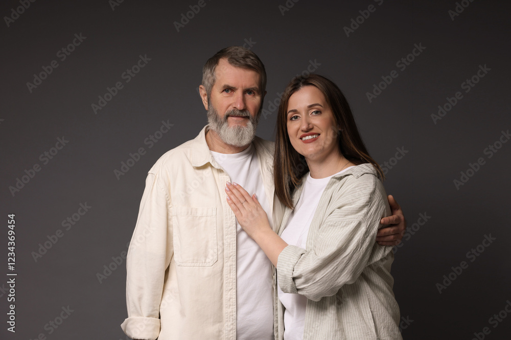 Family portrait of happy daughter and her father on dark background Family portrait of happy daughter and her father on dark background