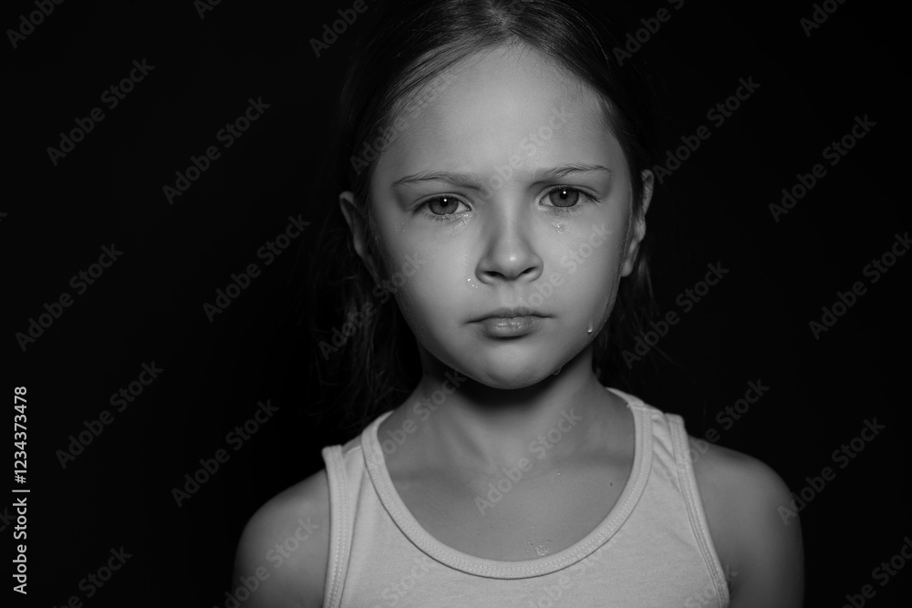 Orphanage concept. Sad girl on dark background. Black and white effect Orphanage concept. Sad girl on dark background. Black and white effect