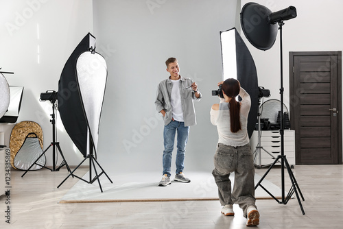 Photographer working with model in professional photo studio