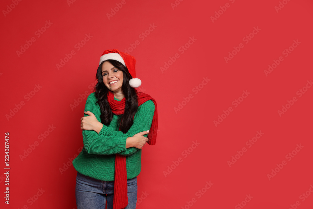 Fototapeta premium Beautiful woman in Santa hat on red background, space for text. Christmas celebration