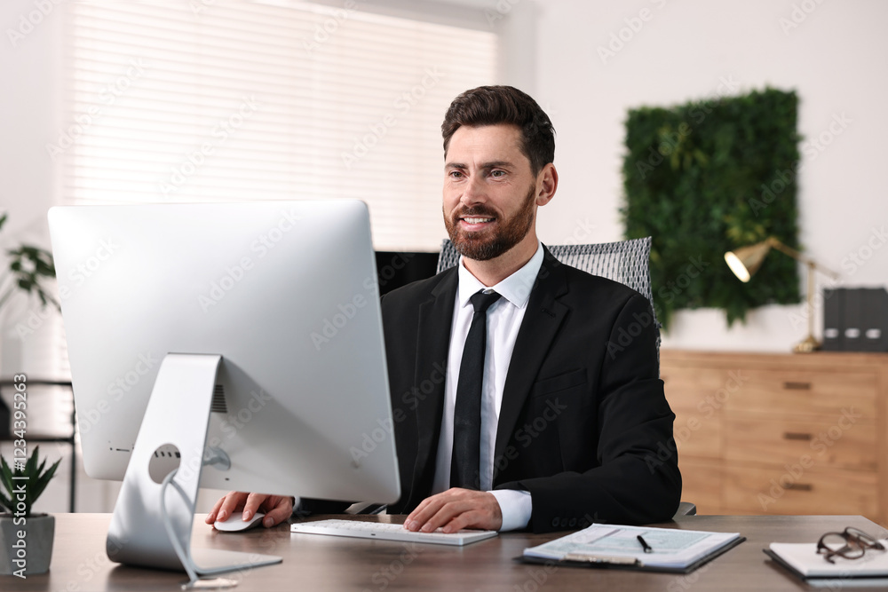 Man working on computer at table in office Man working on computer at table in office
