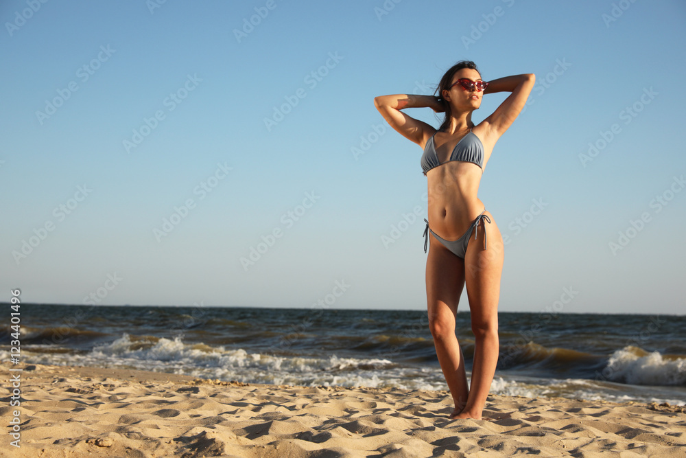 Fototapeta premium Beautiful young woman with attractive body on beach. Space for text