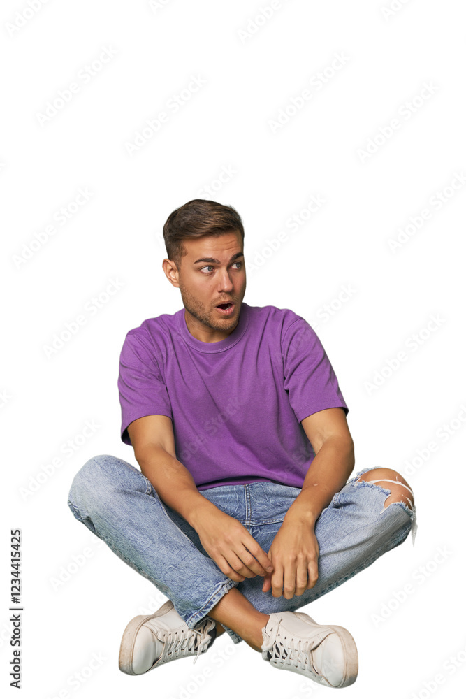 Casual man sitting on floor being shocked because of something she has seen. Casual man sitting on floor being shocked because of something she has seen.