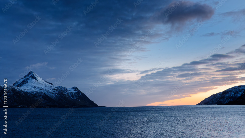 Sunset behind the mountain by the sea. Lofoten Islands, Northern Norway. Sunset behind the mountain by the sea. Lofoten Islands, Northern Norway.