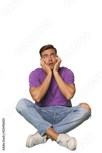 Casual man sitting on floor whining and crying disconsolately. photo