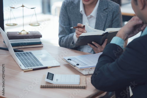 Fotografi Legal Consultation: A legal professional, dressed in a smart suit, carefully reviews a case file with a client