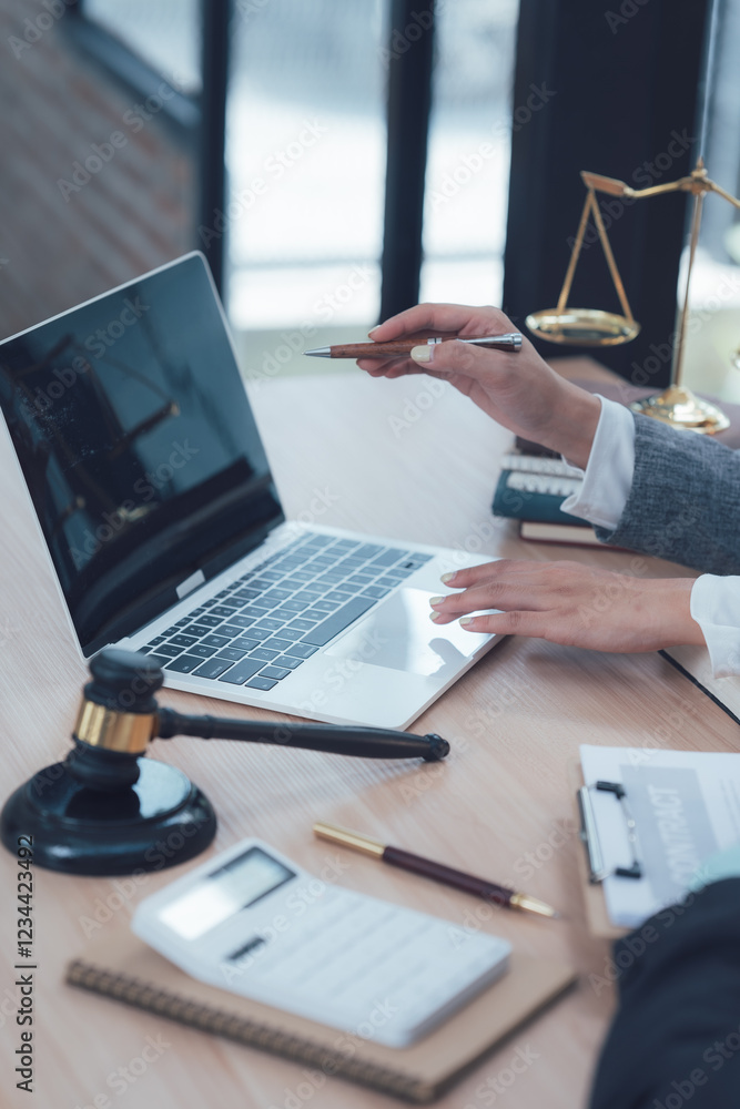 Φωτογραφία Legal Professional Working on Laptop: Close-up shot of a lawyer's hands using a laptop, with a gavel, scales of justice, and legal documents in the frame