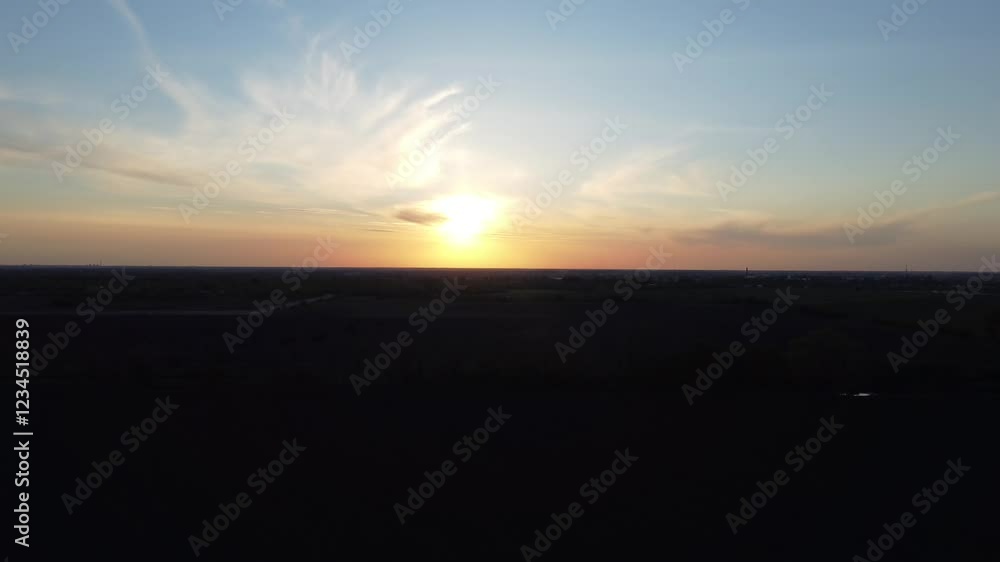 Drone shot capturing a breathtaking sunset over open fields from above. Drone shot capturing a breathtaking sunset over open fields from above.